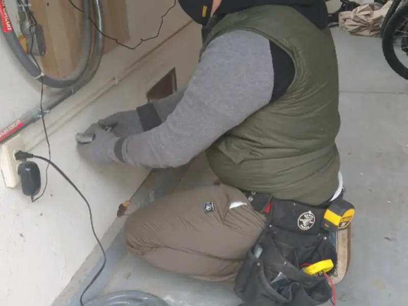Electrician performing outlet wiring in a Trinity garage
